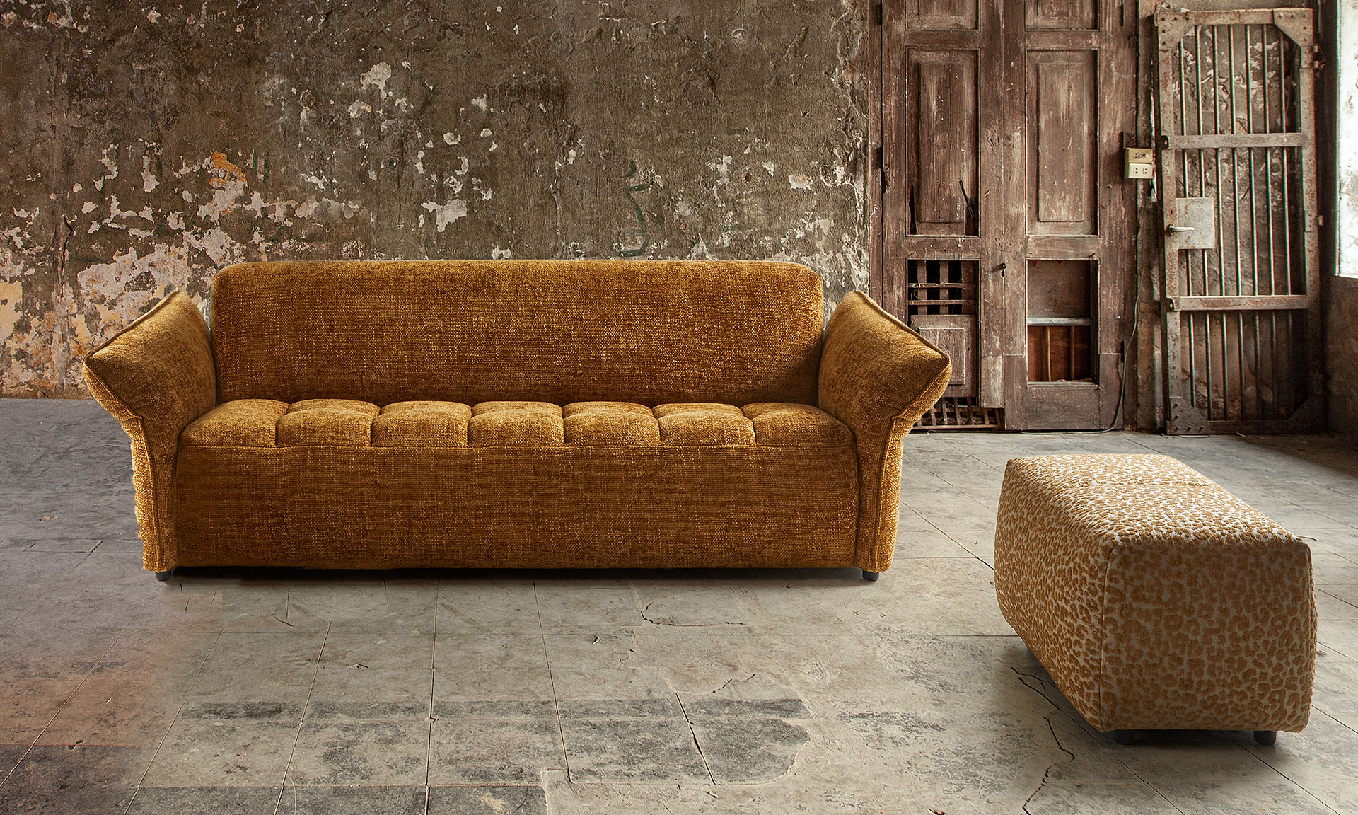 Canapé 2,5 places orange avec assise travailler et des accoudoirs en angle vers l'extérieur. Ainsi qu'un pouf allongé en tissu léopard orange et beige.